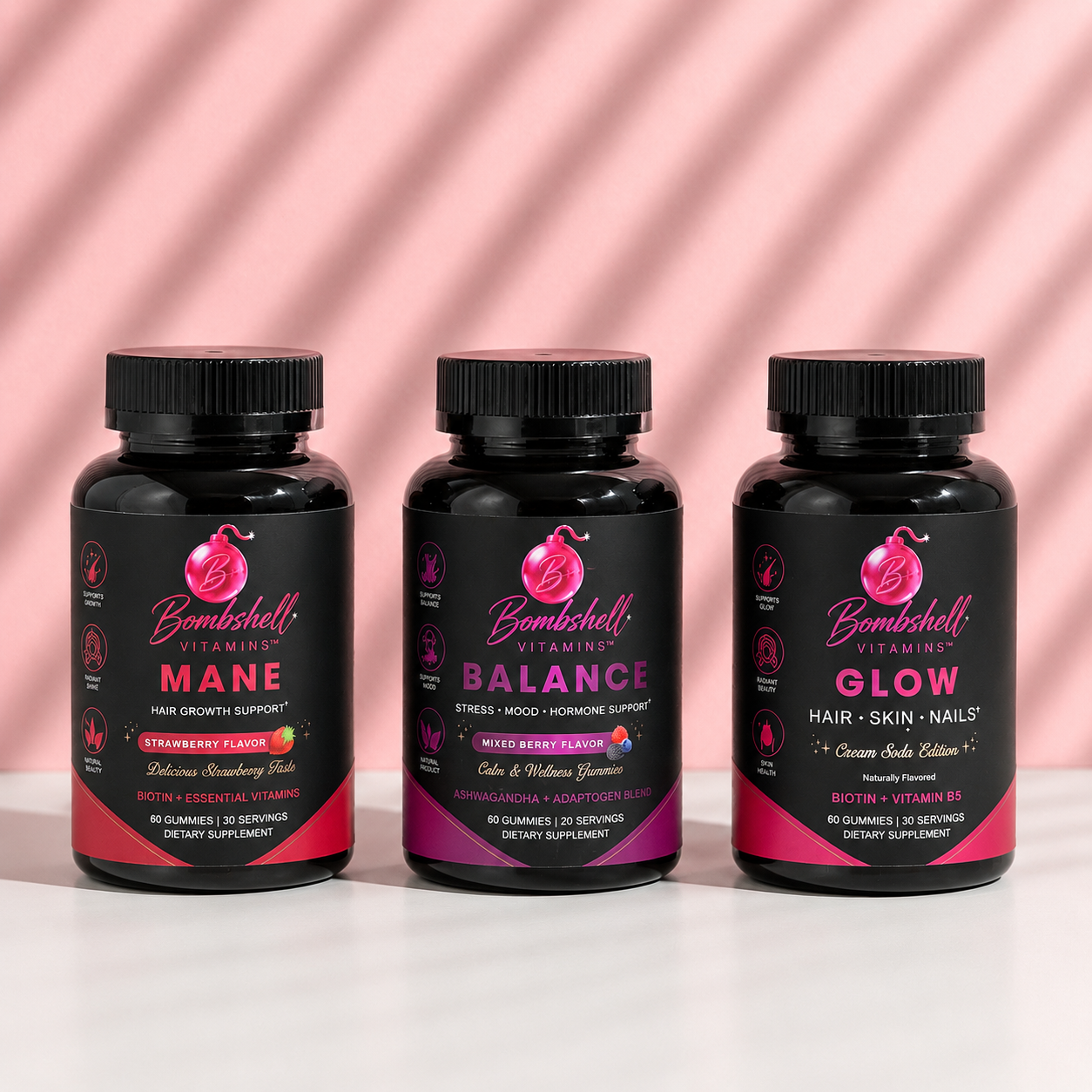Bottles of Bombshell Mane, Balance and Glow arranged together on a pink draped background